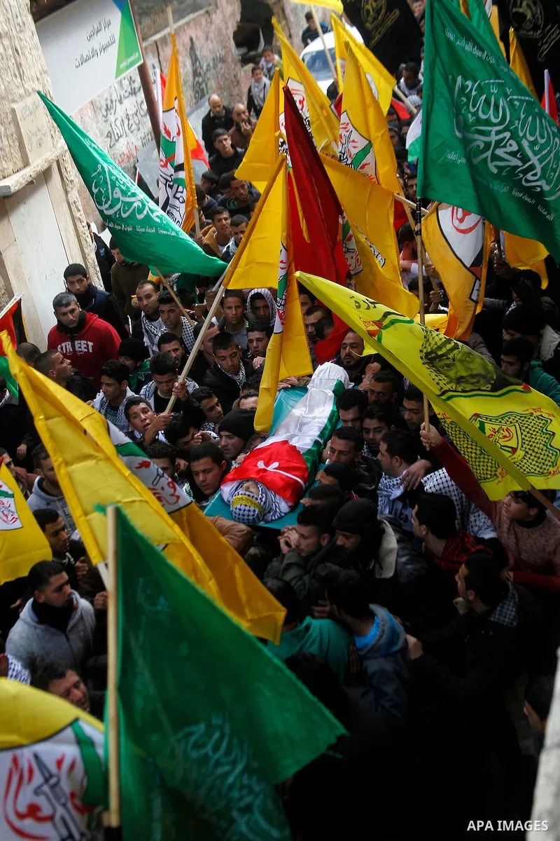 Palestinian mourners carry the body of Omar Jawabra, who was killed by Israeli fire during clashes near Hebron the day before, during his funeral at al-Aroub Palestinian refugee camp, north the West Bank city of Hebron o...