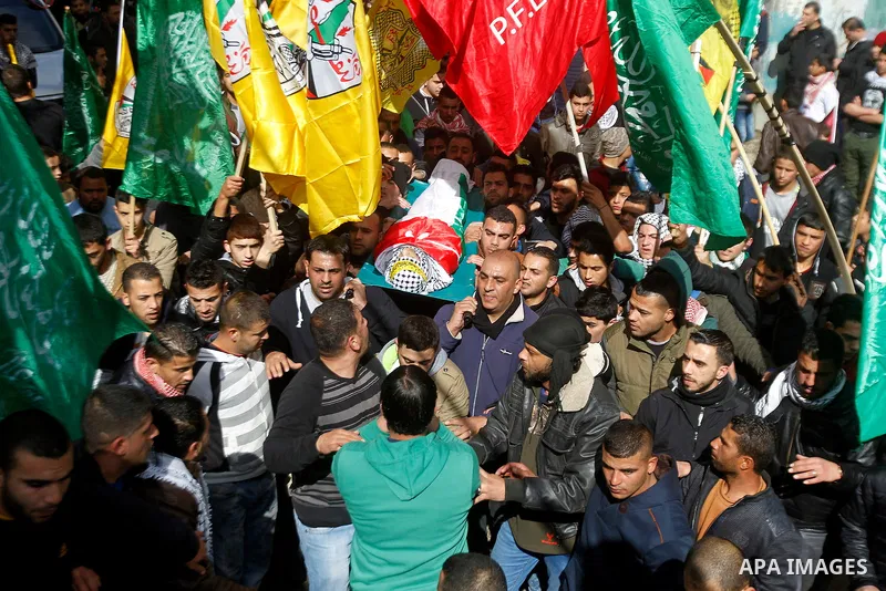 Palestinian mourners carry the body of Omar Jawabra, who was killed by Israeli fire during clashes near Hebron the day before, during his funeral at al-Aroub Palestinian refugee camp, north the West Bank city of Hebron o...