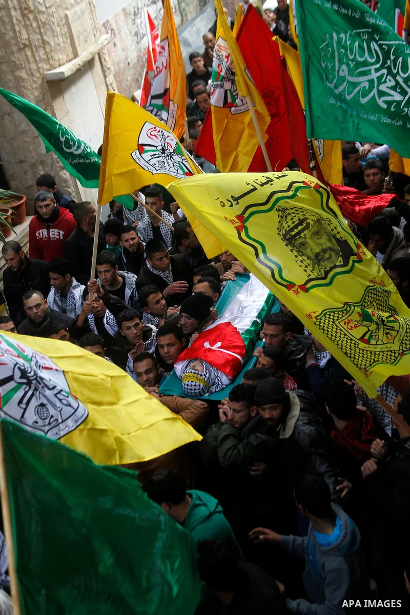 Palestinian mourners carry the body of Omar Jawabra, who was killed by Israeli fire during clashes near Hebron the day before, during his funeral at al-Aroub Palestinian refugee camp, north the West Bank city of Hebron o...