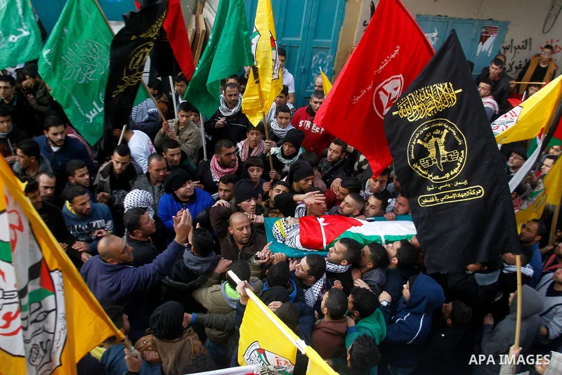 Palestinian mourners carry the body of Omar Jawabra, who was killed by Israeli fire during clashes near Hebron the day before, during his funeral at al-Aroub Palestinian refugee camp, north the West Bank city of Hebron o...