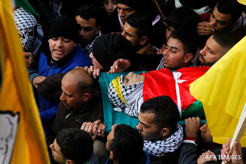 Palestinian mourners carry the body of Omar Jawabra, who was killed by Israeli fire during clashes near Hebron the day before, during his funeral at al-Aroub Palestinian refugee camp, north the West Bank city of Hebron o...