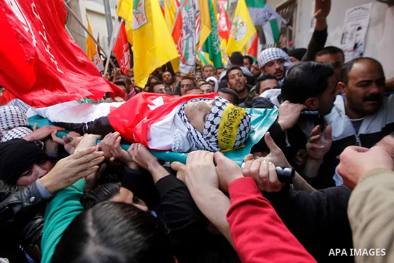 Palestinian mourners carry the body of Omar Jawabra, who was killed by Israeli fire during clashes near Hebron the day before, during his funeral at al-Aroub Palestinian refugee camp, north the West Bank city of Hebron o...