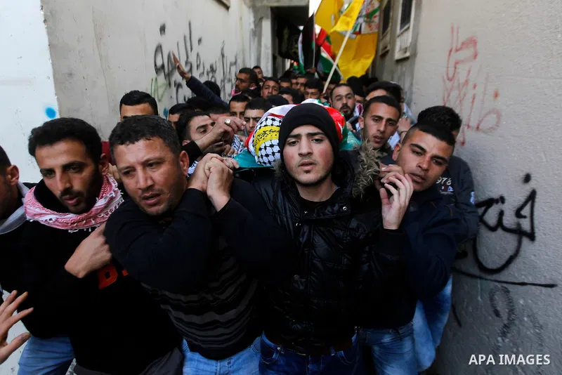 Palestinian mourners carry the body of Omar Jawabra, who was killed by Israeli fire during clashes near Hebron the day before, during his funeral at al-Aroub Palestinian refugee camp, north the West Bank city of Hebron o...