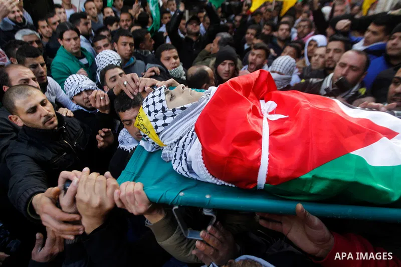 Palestinian mourners carry the body of Omar Jawabra, who was killed by Israeli fire during clashes near Hebron the day before, during his funeral at al-Aroub Palestinian refugee camp, north the West Bank city of Hebron o...
