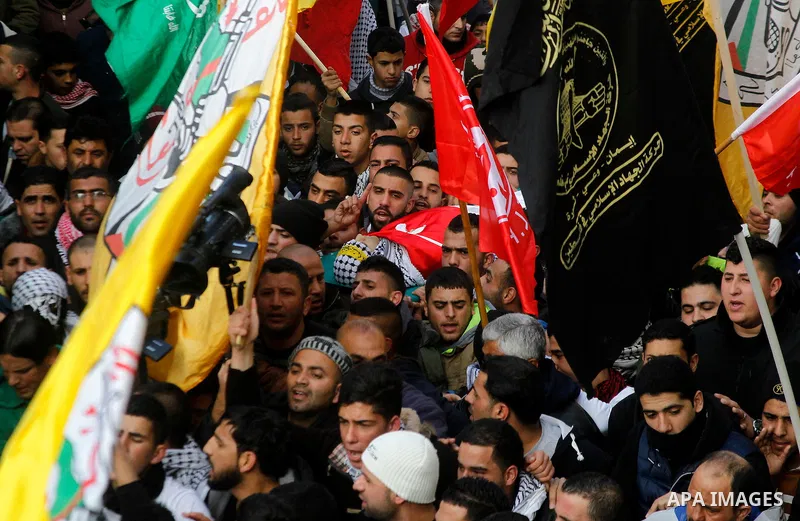 Palestinian mourners carry the body of Omar Jawabra, who was killed by Israeli fire during clashes near Hebron the day before, during his funeral at al-Aroub Palestinian refugee camp, north the West Bank city of Hebron o...