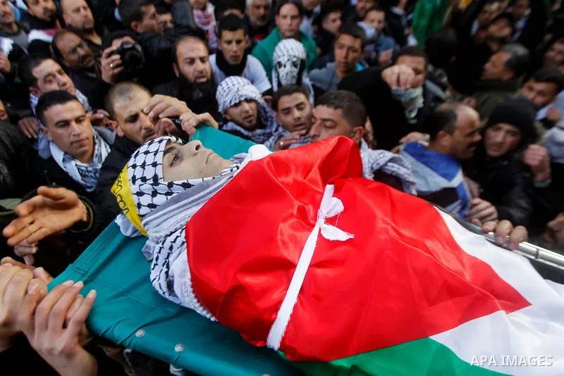Palestinian mourners carry the body of Omar Jawabra, who was killed by Israeli fire during clashes near Hebron the day before, during his funeral at al-Aroub Palestinian refugee camp, north the West Bank city of Hebron o...