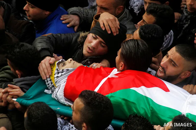 Palestinian mourners carry the body of Omar Jawabra, who was killed by Israeli fire during clashes near Hebron the day before, during his funeral at al-Aroub Palestinian refugee camp, north the West Bank city of Hebron o...