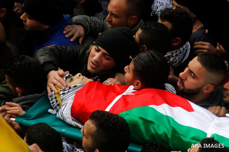Palestinian mourners carry the body of Omar Jawabra, who was killed by Israeli fire during clashes near Hebron the day before, during his funeral at al-Aroub Palestinian refugee camp, north the West Bank city of Hebron o...