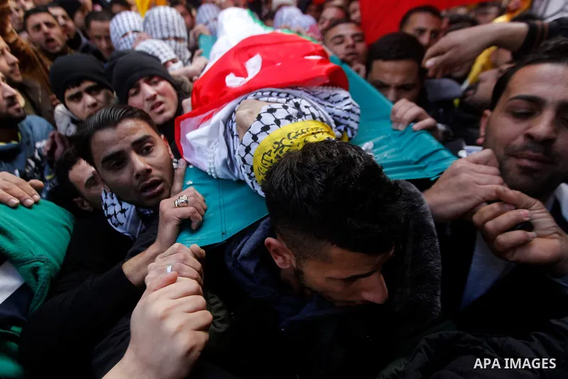 Palestinian mourners carry the body of Omar Jawabra, who was killed by Israeli fire during clashes near Hebron the day before, during his funeral at al-Aroub Palestinian refugee camp, north the West Bank city of Hebron o...