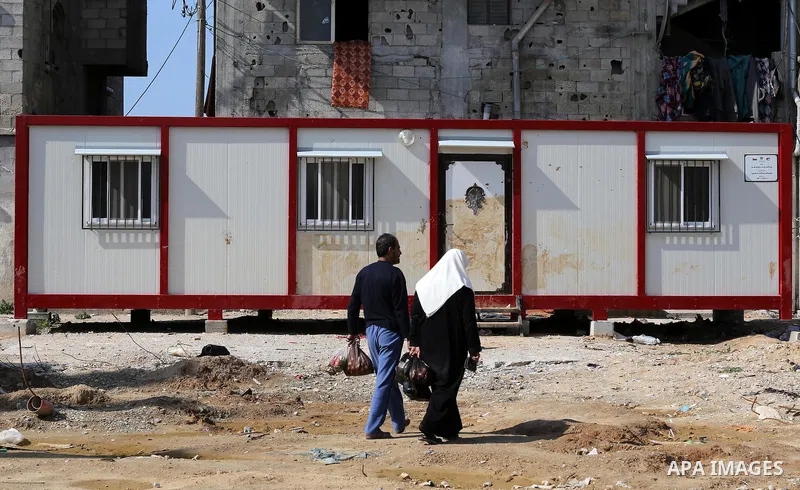 Palestinians walk past a house wihch destroyed during 2014 war, in Shijaiyah neighborhood in the east of Gaza city on Feb. 11, 2016. Rebuilding of Palestinian houses which destroyed during 2014 war and funded by Kuwaiti...
