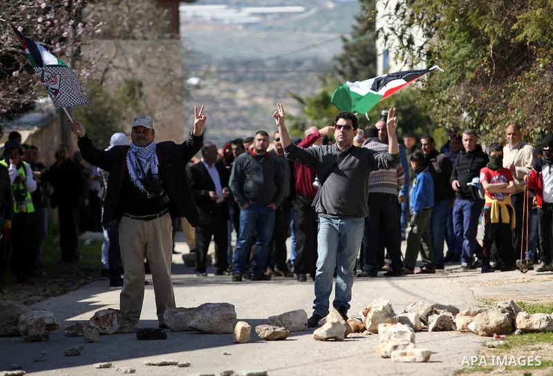 Palestinian protesters flash victory sign during clashes with Israeli security forces following a protest against the expropriation of Palestinian land by Israel in the West Bank village of Kafr Qaddum, near the northern...