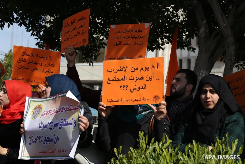 Palestinians hold posters during a protest in support of hunger striking Palestinian journalist Mohammed al-Qiq, in Gaza city on February 13, 2016. The 33-year-old television reporter will keep up his 10-week hunger stri...
