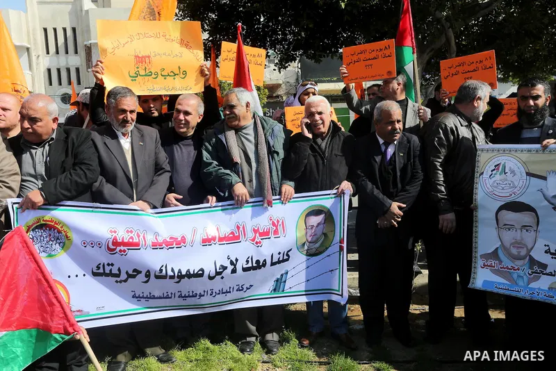 Palestinians hold posters during a protest in support of hunger striking Palestinian journalist Mohammed al-Qiq, in Gaza city on February 13, 2016. The 33-year-old television reporter will keep up his 10-week hunger stri...