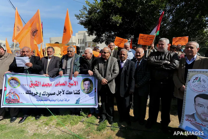 Palestinians hold posters during a protest in support of hunger striking Palestinian journalist Mohammed al-Qiq, in Gaza city on February 13, 2016. The 33-year-old television reporter will keep up his 10-week hunger stri...