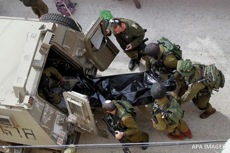 Israeli security forces carry the body of a Palestinian woman tried to stab an Israeli soldier before being shot dead, in the Israeli occupied West Bank city of Hebron, on February 13, 2016. An Israeli army statement sai...