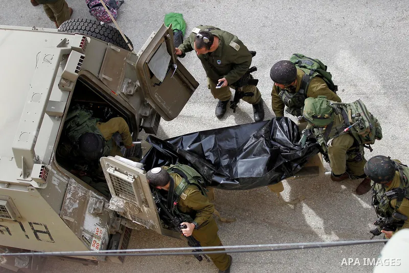 Israeli security forces carry the body of a Palestinian woman tried to stab an Israeli soldier before being shot dead, in the Israeli occupied West Bank city of Hebron, on February 13, 2016. An Israeli army statement sai...