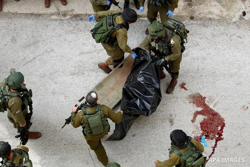 Israeli security forces carry the body of a Palestinian woman tried to stab an Israeli soldier before being shot dead, in the Israeli occupied West Bank city of Hebron, on February 13, 2016. An Israeli army statement sai...