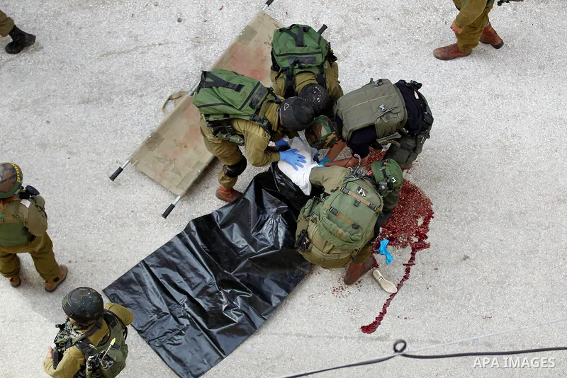 Israeli security forces carry the body of a Palestinian woman tried to stab an Israeli soldier before being shot dead, in the Israeli occupied West Bank city of Hebron, on February 13, 2016. An Israeli army statement sai...