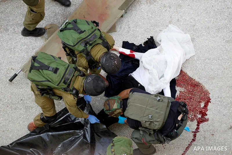 Israeli security forces carry the body of a Palestinian woman tried to stab an Israeli soldier before being shot dead, in the Israeli occupied West Bank city of Hebron, on February 13, 2016. An Israeli army statement sai...