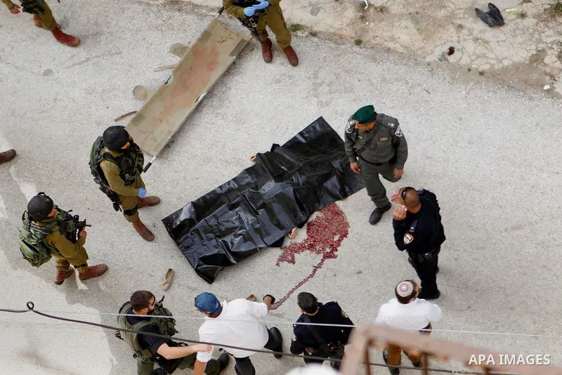 Israeli security forces carry the body of a Palestinian woman tried to stab an Israeli soldier before being shot dead, in the Israeli occupied West Bank city of Hebron, on February 13, 2016. An Israeli army statement sai...