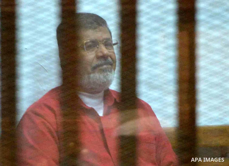 Ousted Egyptian president Mohammed Morsi sits behind bars during his trail as part of the so-called 'Qatar espionage' case, in a court in Cairo on Feb. 13, 2016. The defendants are accused of 'leaking important national...