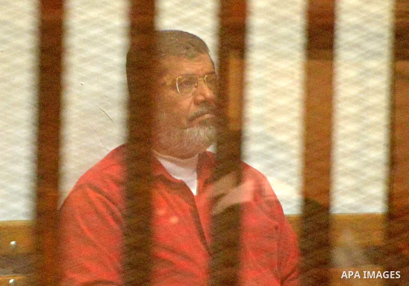Ousted Egyptian president Mohammed Morsi sits behind bars during his trail as part of the so-called 'Qatar espionage' case, in a court in Cairo on Feb. 13, 2016. The defendants are accused of 'leaking important national...