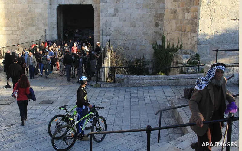 Palestinians walk in front of Damascus Gate, a main entrance to Jerusalem's Old City on February 13, 2016. Photo by Mahfouz Abu Turk