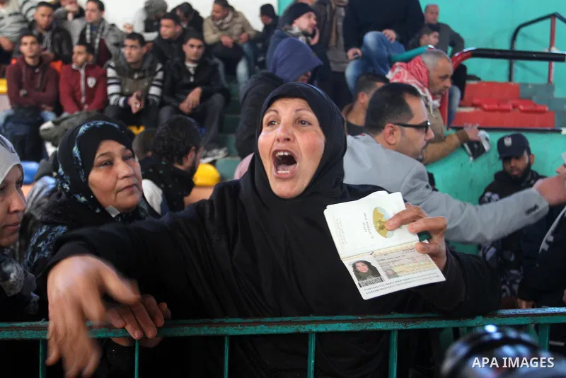 A woman reacts as she waits for a travel permit to cross into Egypt through the Rafah border crossing between Egypt and the southern Gaza Strip February 14, 2016. Egypt opened the Rafah border crossing on Saturday for tw...
