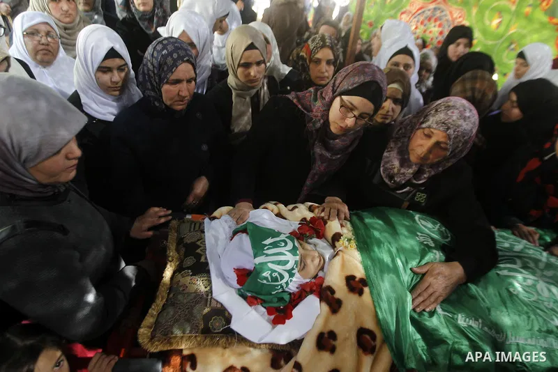 The relatives of Palestinian Kalzar al-Uweiwi, a Palestinian teenager who was killed a day earlier following a reported stabbing attack, mourn over her body ahead of her funeral, in the Israeli occupied West Bank city of...