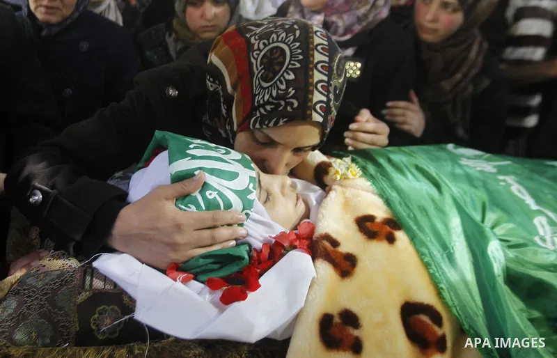 The relatives of Palestinian Kalzar al-Uweiwi, a Palestinian teenager who was killed a day earlier following a reported stabbing attack, mourn over her body ahead of her funeral, in the Israeli occupied West Bank city of...