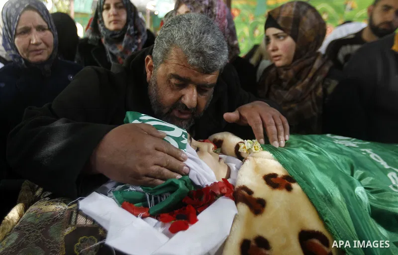The relatives of Palestinian Kalzar al-Uweiwi, a Palestinian teenager who was killed a day earlier following a reported stabbing attack, mourn over her body ahead of her funeral, in the Israeli occupied West Bank city of...