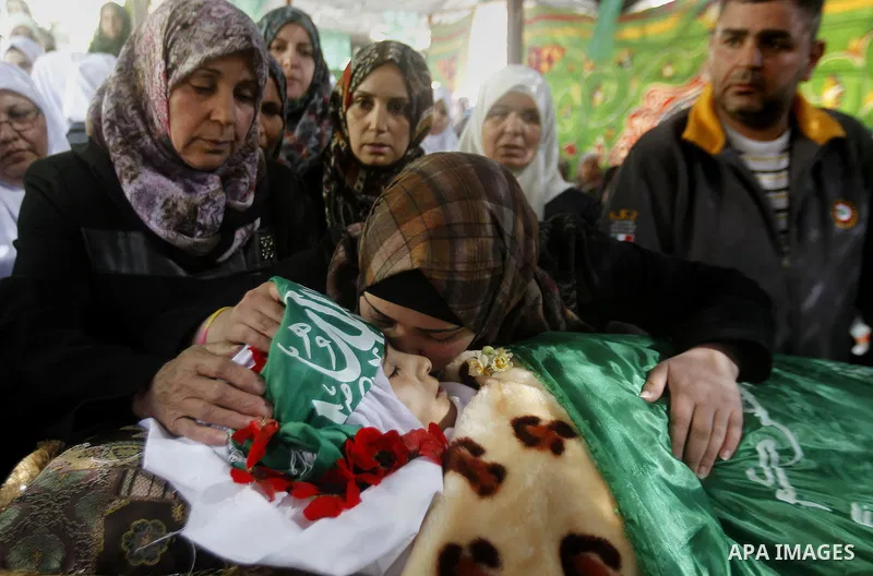 The relatives of Palestinian Kalzar al-Uweiwi, a Palestinian teenager who was killed a day earlier following a reported stabbing attack, mourn over her body ahead of her funeral, in the Israeli occupied West Bank city of...