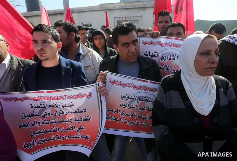 Palestinians hold posters during a protest in support of hunger striking Palestinian journalist Mohammed al-Qiq, in Gaza city on February 14, 2016. The 33-year-old television reporter will keep up his 10-week hunger stri...
