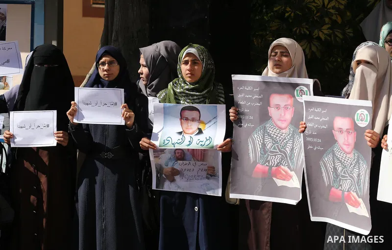 Palestinians hold posters during a protest in support of hunger striking Palestinian journalist Mohammed al-Qiq, in Gaza city on February 14, 2016. The 33-year-old television reporter will keep up his 10-week hunger stri...