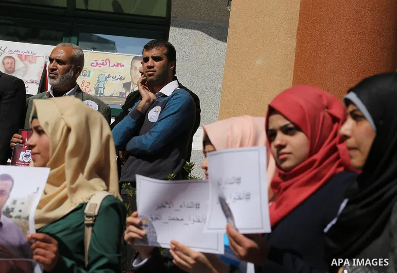 Palestinians hold posters during a protest in support of hunger striking Palestinian journalist Mohammed al-Qiq, in Gaza city on February 14, 2016. The 33-year-old television reporter will keep up his 10-week hunger stri...