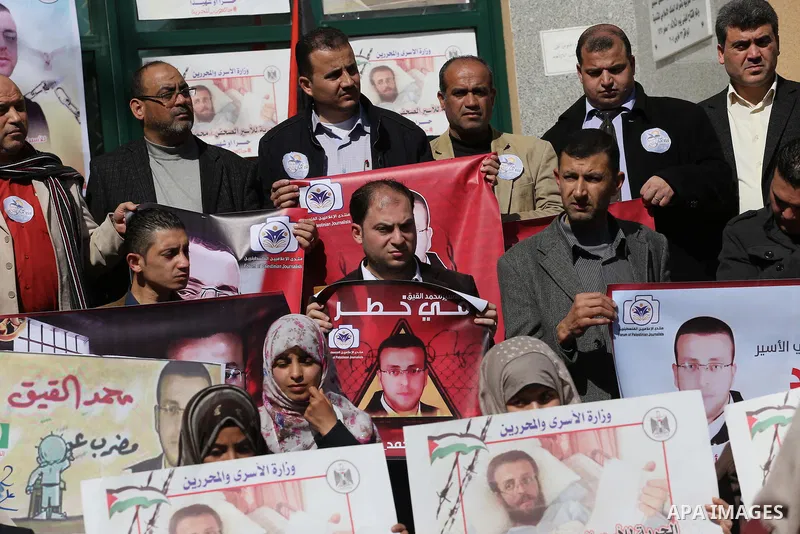 Palestinians hold posters during a protest in support of hunger striking Palestinian journalist Mohammed al-Qiq, in Gaza city on February 14, 2016. The 33-year-old television reporter will keep up his 10-week hunger stri...