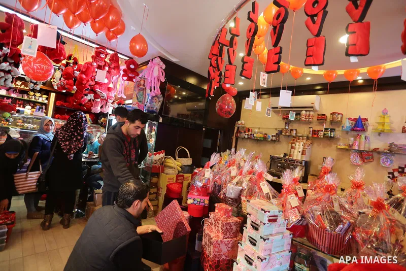 Palestinian vendors display flowers red teddy bears and pillows on Valentine's day in Gaza on February 14, 2016. Valentine's Day is increasingly popular in the region as people have taken up the custom of giving flowers,...
