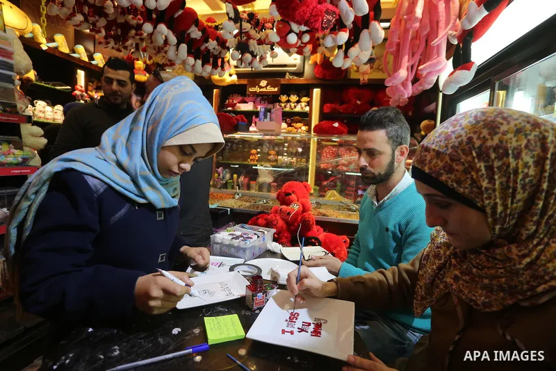 Palestinian vendors display flowers red teddy bears and pillows on Valentine's day in Gaza on February 14, 2016. Valentine's Day is increasingly popular in the region as people have taken up the custom of giving flowers,...