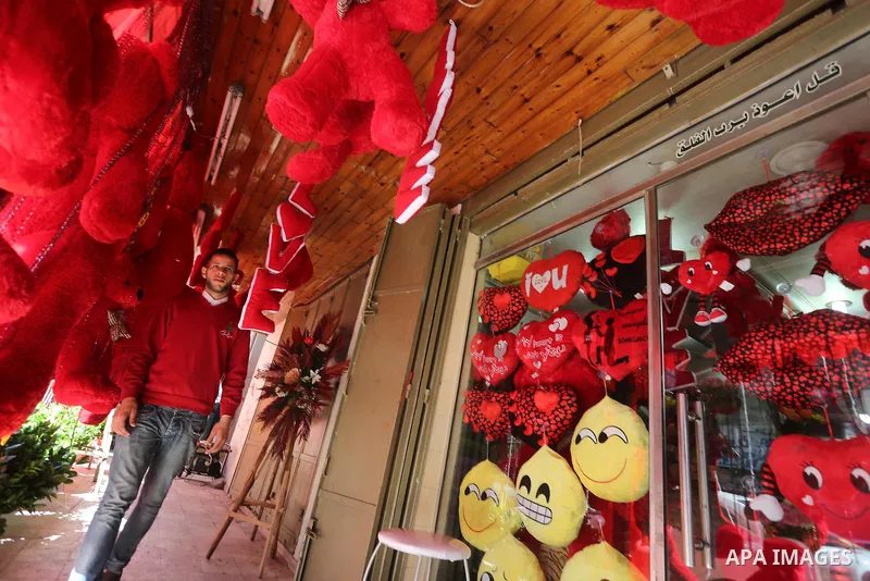 Palestinian vendors display flowers red teddy bears and pillows on Valentine's day in Gaza on February 14, 2016. Valentine's Day is increasingly popular in the region as people have taken up the custom of giving flowers,...