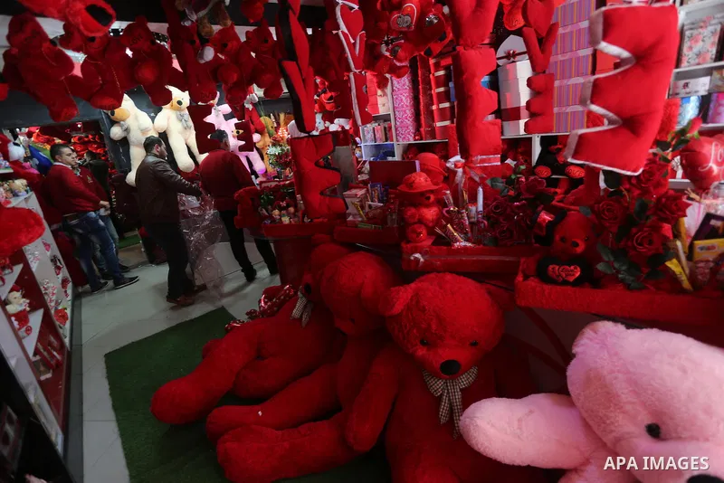 Palestinian vendors display flowers red teddy bears and pillows on Valentine's day in Gaza on February 14, 2016. Valentine's Day is increasingly popular in the region as people have taken up the custom of giving flowers,...