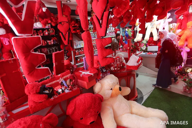 Palestinian vendors display flowers red teddy bears and pillows on Valentine's day in Gaza on February 14, 2016. Valentine's Day is increasingly popular in the region as people have taken up the custom of giving flowers,...