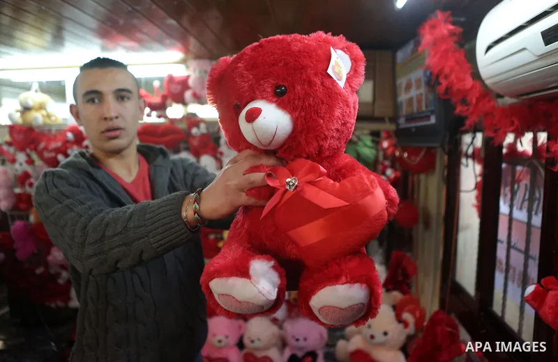 Palestinian vendors display flowers red teddy bears and pillows on Valentine's day in the West Bank city of Ramallah, on February 14, 2016. Valentine's Day is increasingly popular in the region as people have taken up th...