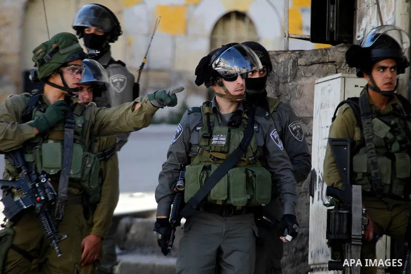 Israeli security forces take position during clashes with Palestinian protesters following the funeral of Kalzar al-Uweiwi, a Palestinian teenager who was killed a day earlier following a reported stabbing attack, in the...