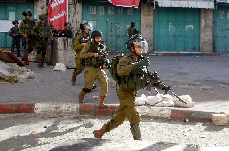 Israeli security forces take position during clashes with Palestinian protesters following the funeral of Kalzar al-Uweiwi, a Palestinian teenager who was killed a day earlier following a reported stabbing attack, in the...