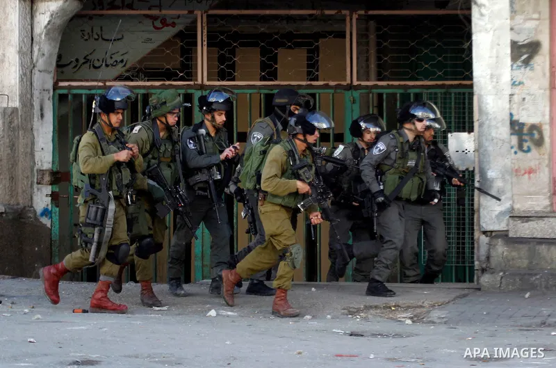 Israeli security forces take position during clashes with Palestinian protesters following the funeral of Kalzar al-Uweiwi, a Palestinian teenager who was killed a day earlier following a reported stabbing attack, in the...
