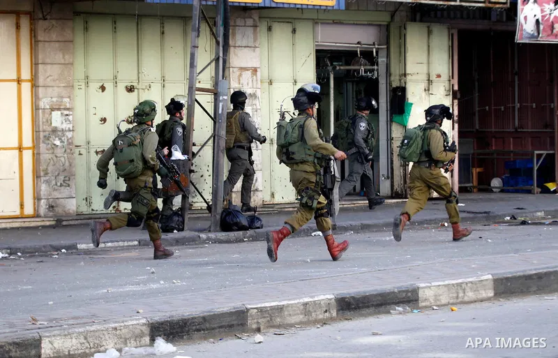 Israeli security forces take position during clashes with Palestinian protesters following the funeral of Kalzar al-Uweiwi, a Palestinian teenager who was killed a day earlier following a reported stabbing attack, in the...