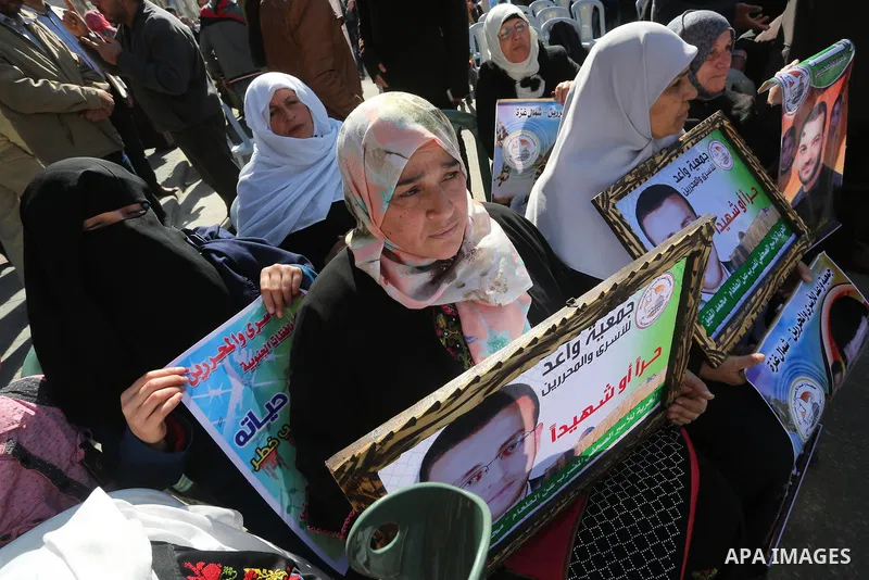 Palestinians hold posters during a protest in support of hunger striking Palestinian journalist Mohammed al-Qiq, in front of the Red cross office, Gaza city on February 14, 2016. The 33-year-old television reporter will...