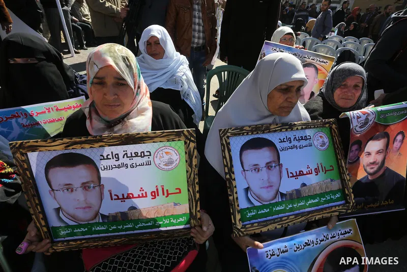 Palestinians hold posters during a protest in support of hunger striking Palestinian journalist Mohammed al-Qiq, in front of the Red cross office, Gaza city on February 14, 2016. The 33-year-old television reporter will...