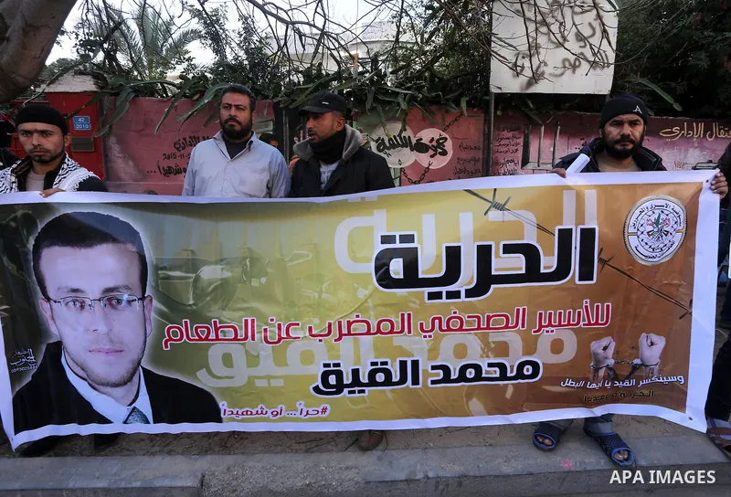 Palestinians hold posters during a protest in support of hunger striking Palestinian journalist Mohammed al-Qiq, in front of the Red cross office, Gaza city on February 14, 2016. The 33-year-old television reporter will...