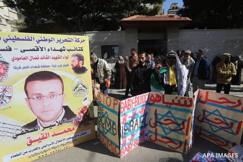 Palestinians hold posters during a protest in support of hunger striking Palestinian journalist Mohammed al-Qiq, in front of the Red cross office, Gaza city on February 14, 2016. The 33-year-old television reporter will...